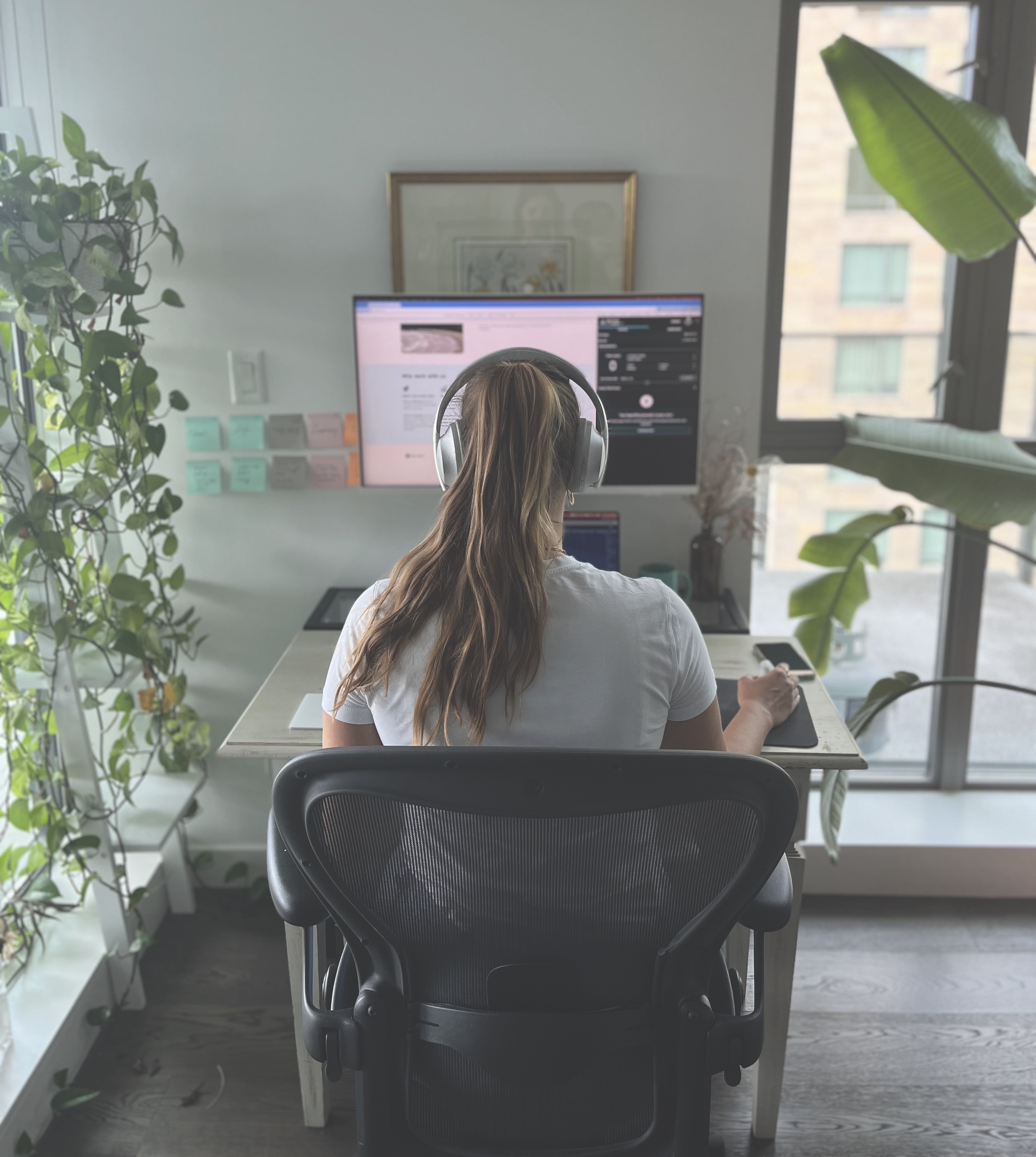 A shot from behind Laetitia in Easy Surf’s home office. She’s sitting at her desk and auditing a website with her automated accessibility tool. She’s wearing a white t-shirt, and her long dark-blonde hair is in a pony tail.