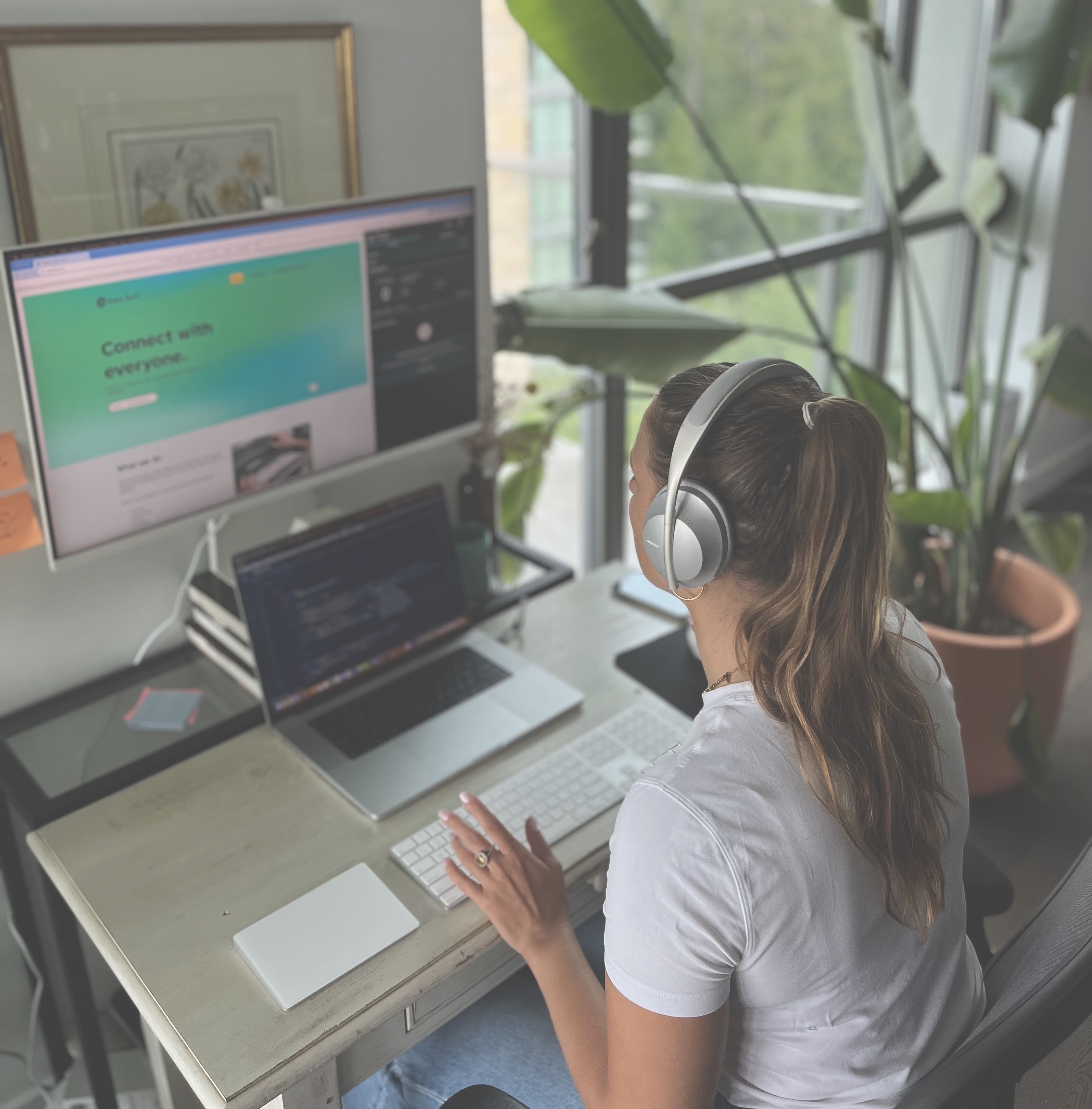 A shot from Laetitia’s left in Easy Surf’s home office. She’s sitting at her desk and reviewing accessibility fixes with her automated accessibility tool. She’s wearing a white t-shirt, and her long dark-blonde hair is in a ponytail.